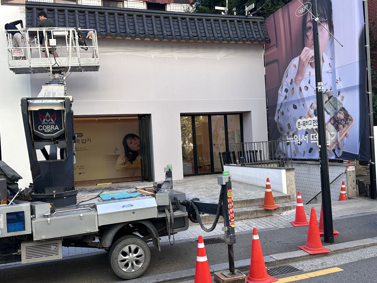 기와가 모두 설치된 파사드와 오른쪽 대형 현수막