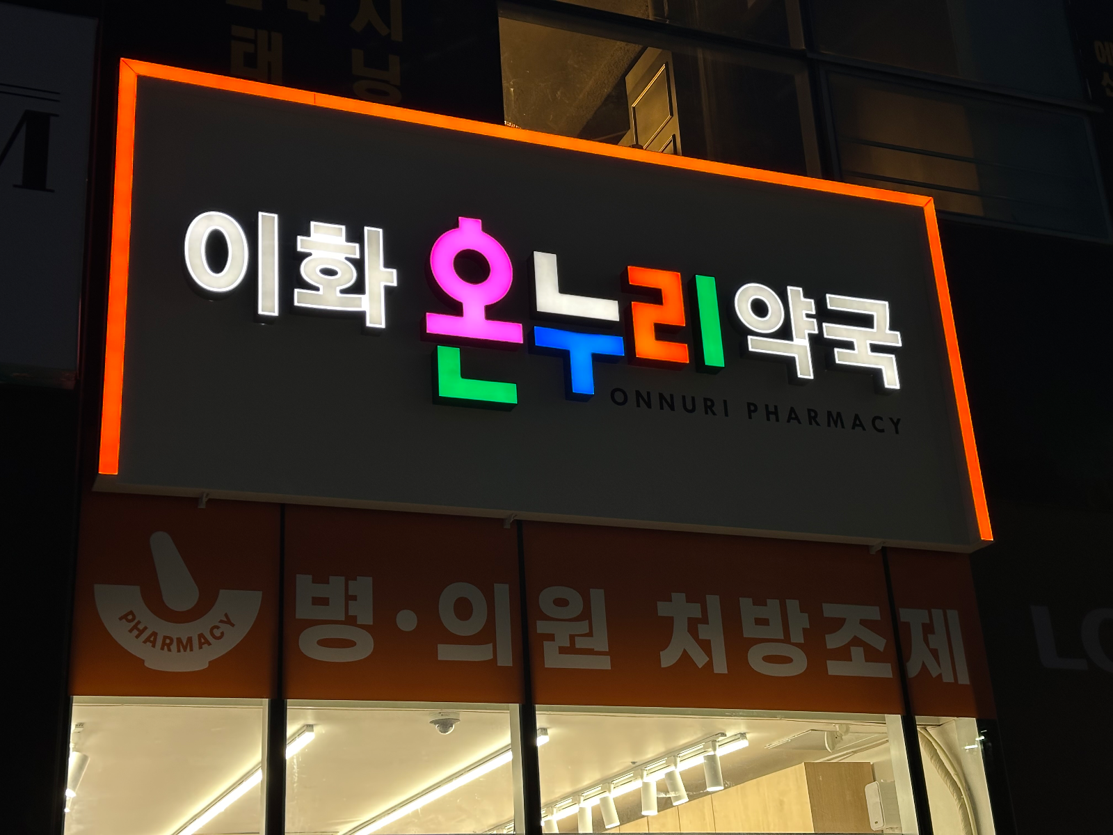 야간에 점등된 약국 간판. 글자와 테두리가 빛남
