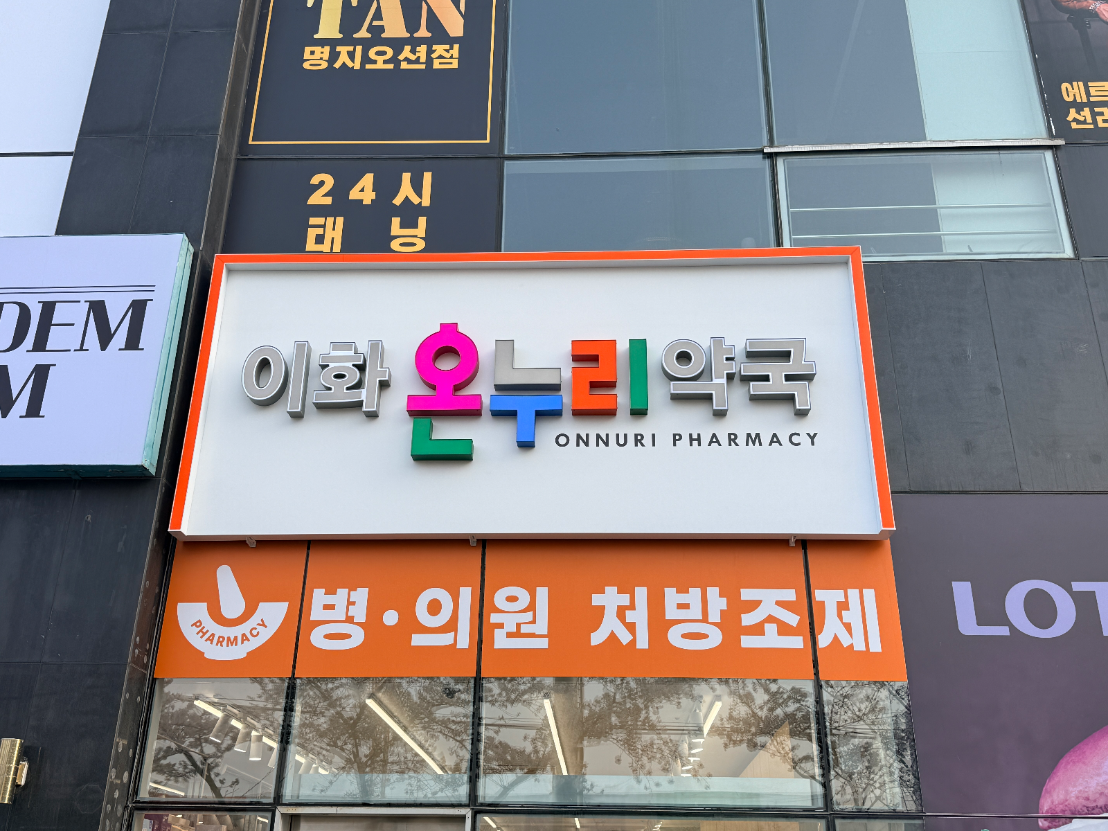 정면에서 본 이화온누리약국 간판. 은색과 컬러 입체 글자, 주황 테두리