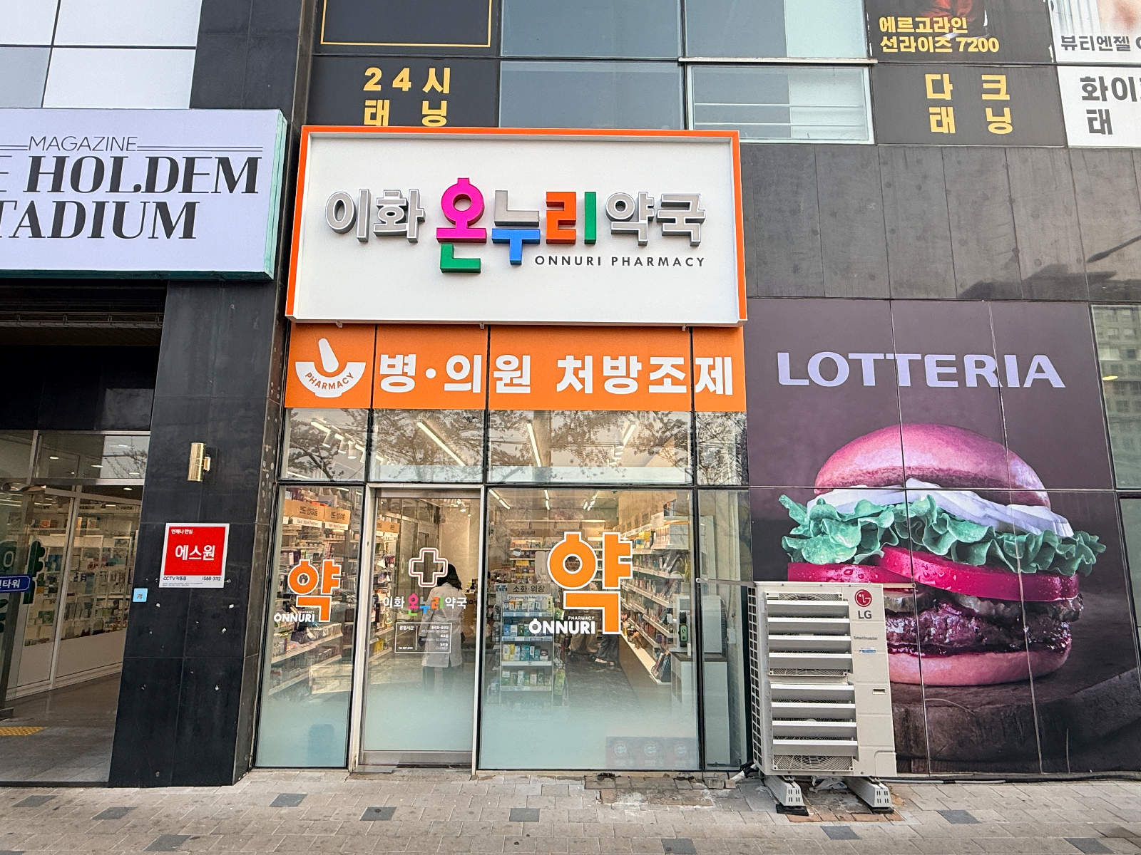 교체 후 이화온누리약국 외관 전경. 흰 바탕에 주황 테두리 간판과 주황 처방조제 띠