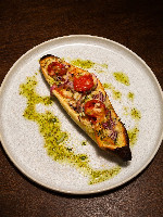 Bruschetta de tomates confit, alho e molho pesto