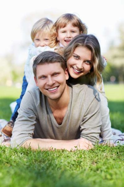 A family posing together while lying on top of each other largest to smallest.