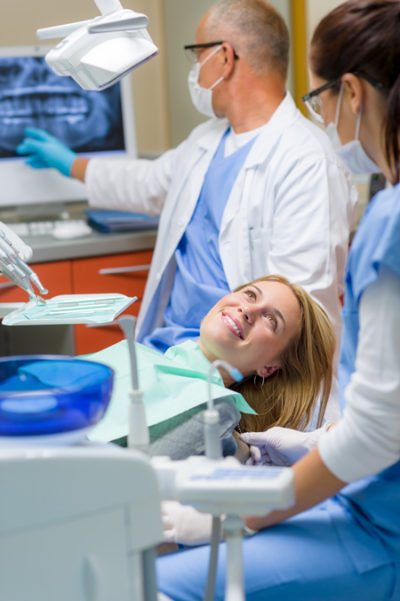 woman with dentist getting Wisdom Teeth Extraction