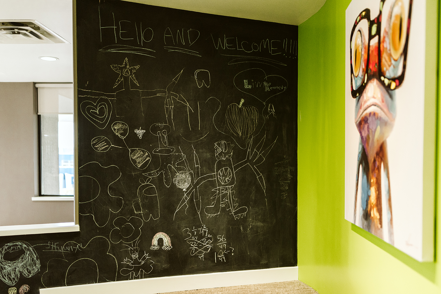 The kids waiting room at Vita Dental wellness with a chalk board and a fun frog painting.