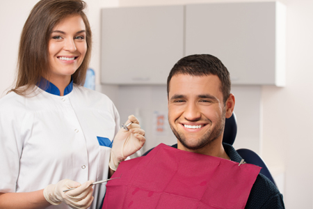 A man smiling with his dental hygienist.