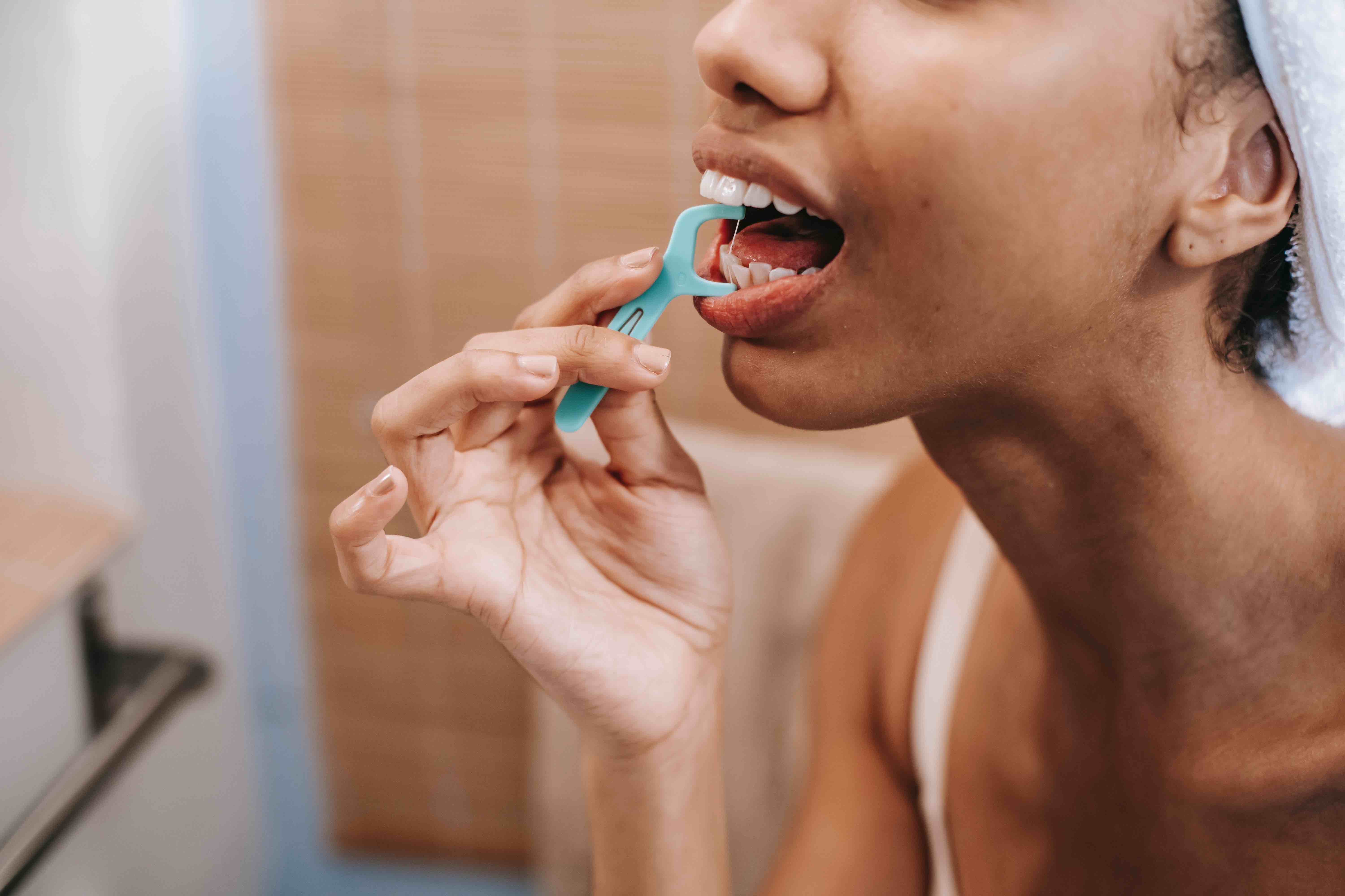 woman flossing in her bathroom