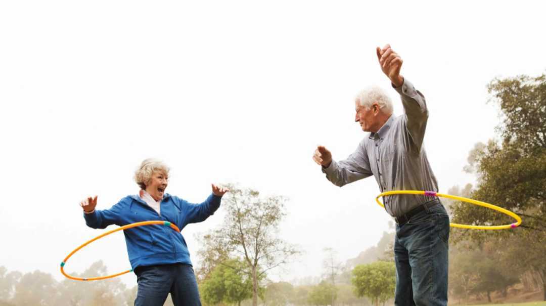 older couple doing hula-hoop contently 