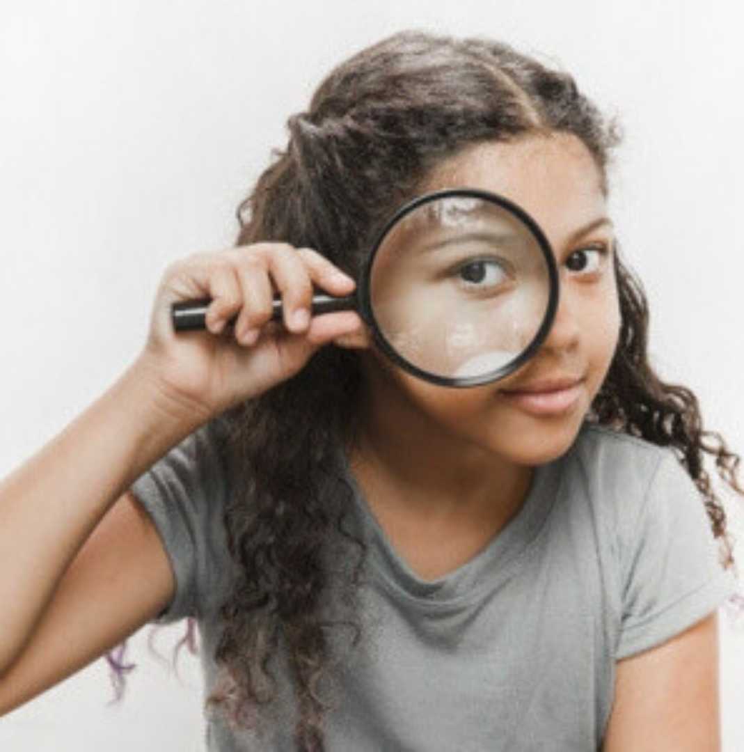 girl looking through a magnifying glass