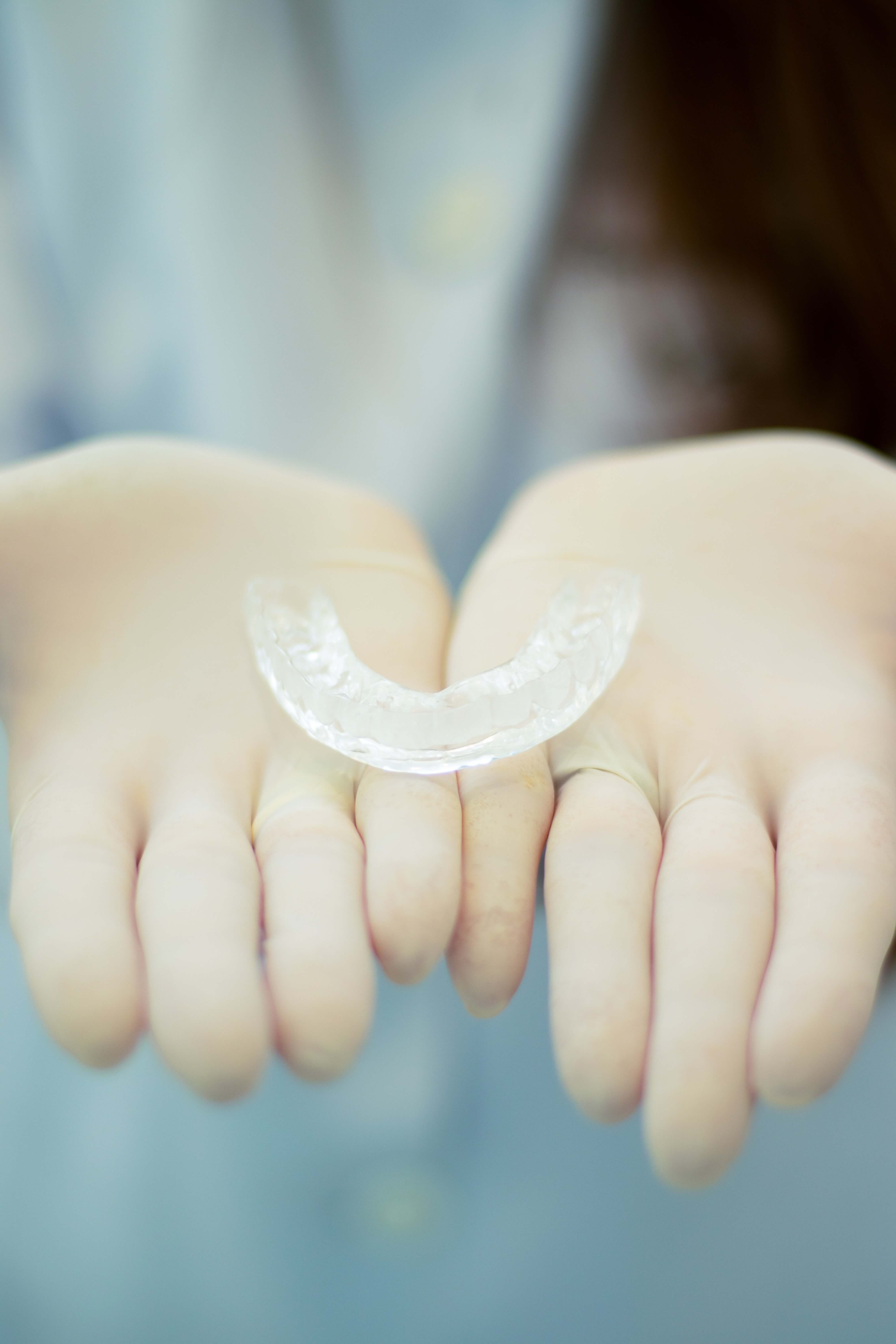 two hands holding an invisalign tray