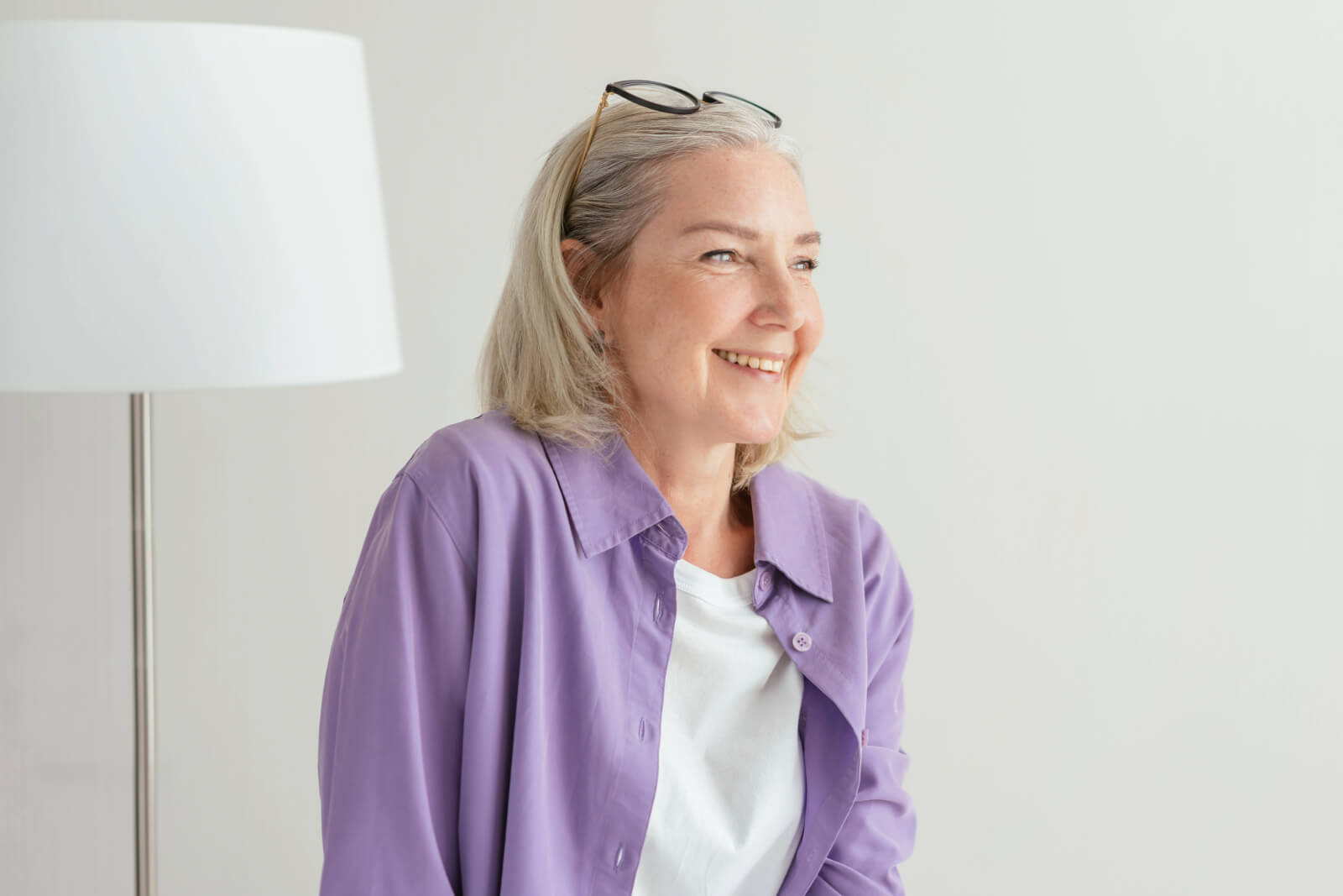 woman while sitting on a chair on a light background