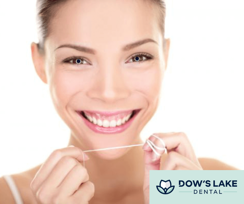 woman with a bright smile starting to floss her teeth