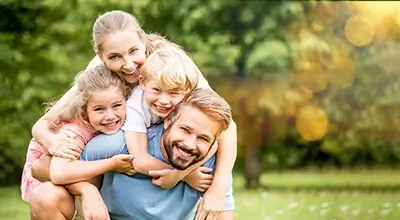 family hugging playfully while smiling