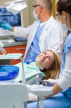 women in dentist chair smiling at dentist 