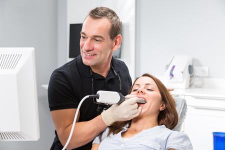 dentist looking at a display screen for the scanner