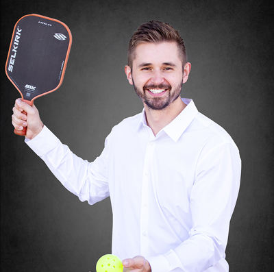 Doctor Lucas Stepanko hitting a tennis ball with a racket.