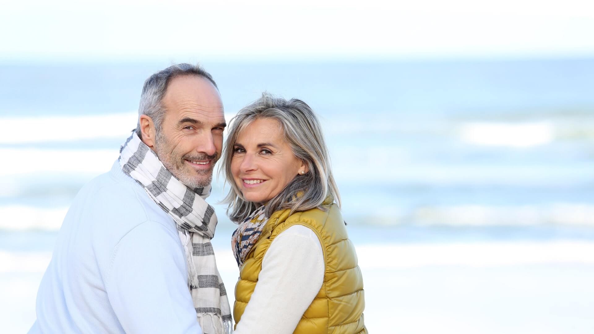 A couple holding hands on the by the water.