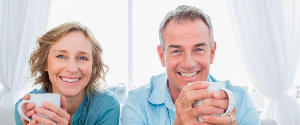 People smiling and a holding mugs.