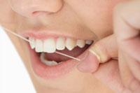 close up image of a person flossing their teeth