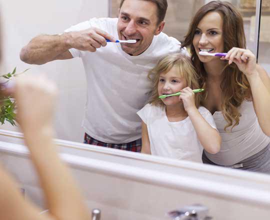 a family brushing their teeth together in the morning