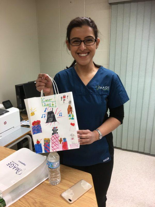 dr. holding up a gift bag made by one of her young patients