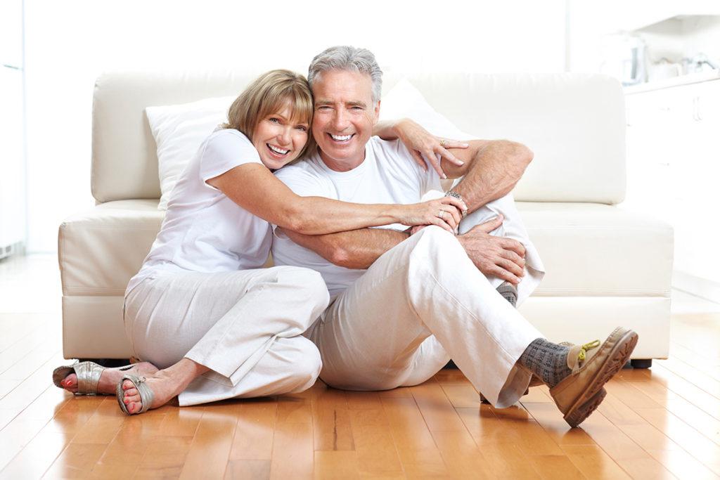 older couple hugging and smiling with nice teeth
