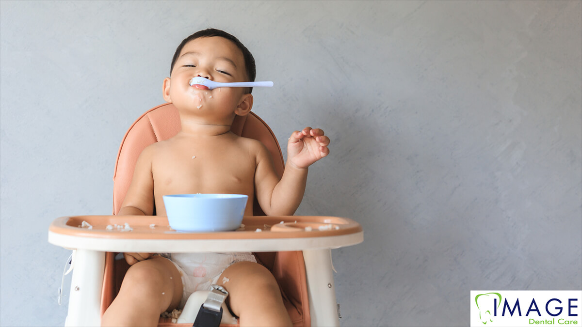 A baby eating in a high chair.