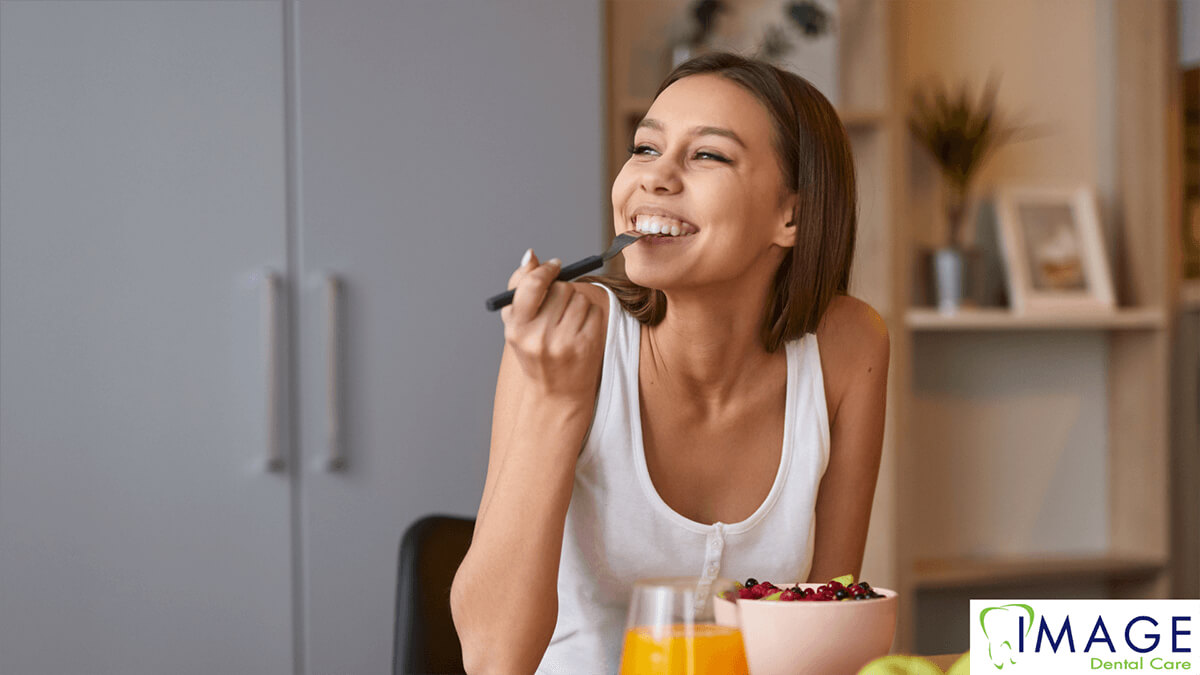 A woman eating a bowl of berries.