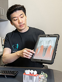 Markham Dental staff showing a photo on a tablet