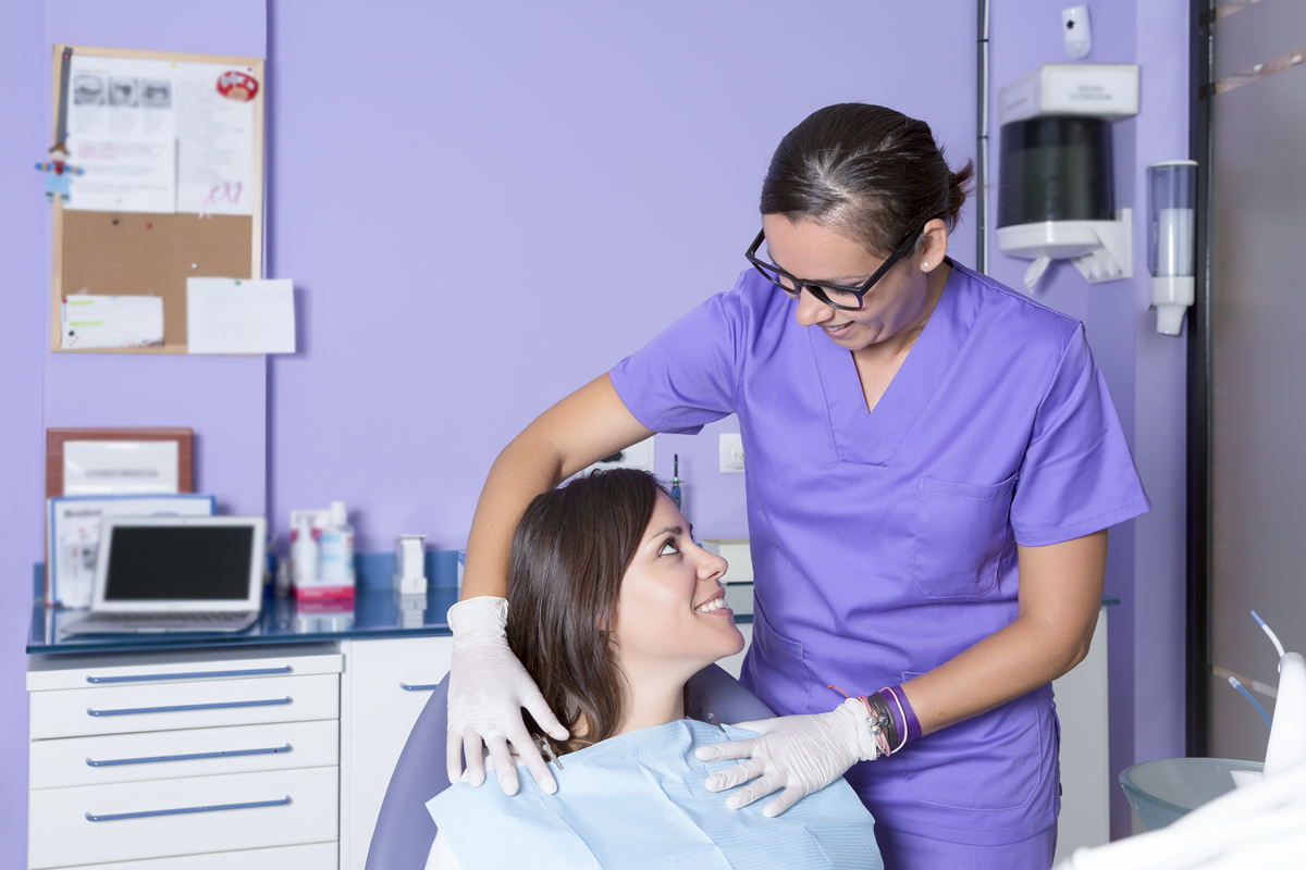 A dentist reassuring her patient before an extraction.