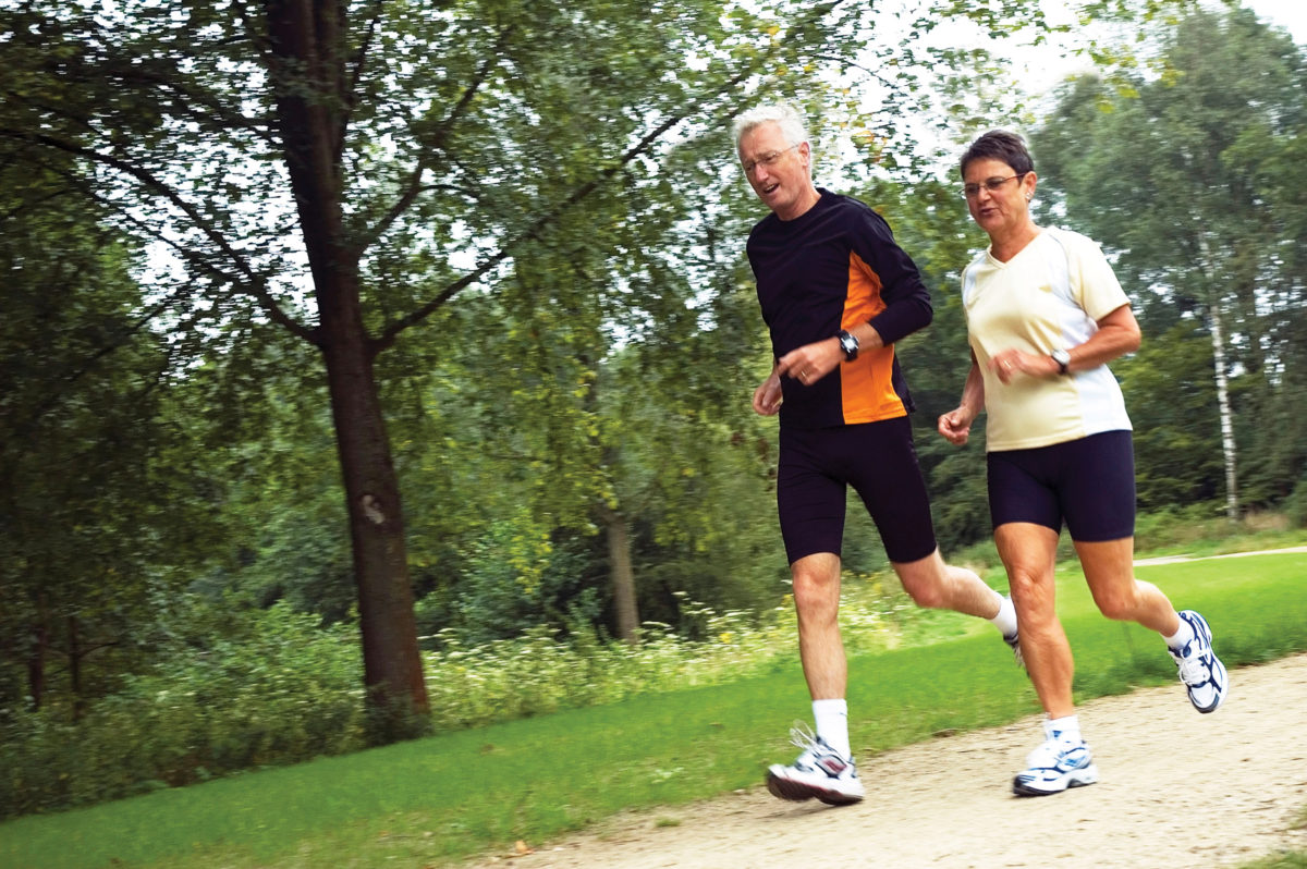 Healthy couple running in park.