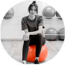 A woman sitting on an exercise ball.