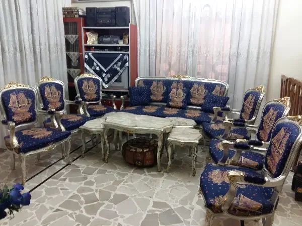 غرفة ضيوف لون كحلي مع طاولات