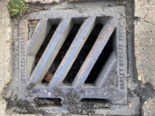 Waste visible inside the blocked external gully before clearance.