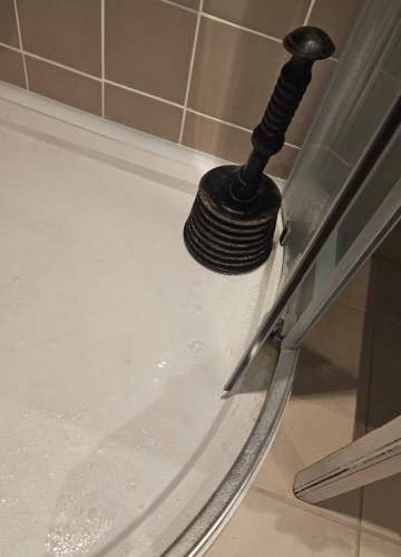 Severe debris restriction inside shower waste before clearance in NR25 Holt.