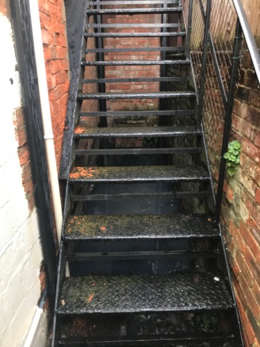 Restricted access to gullies beneath a cast iron staircase at a property in Devizes (SN10).