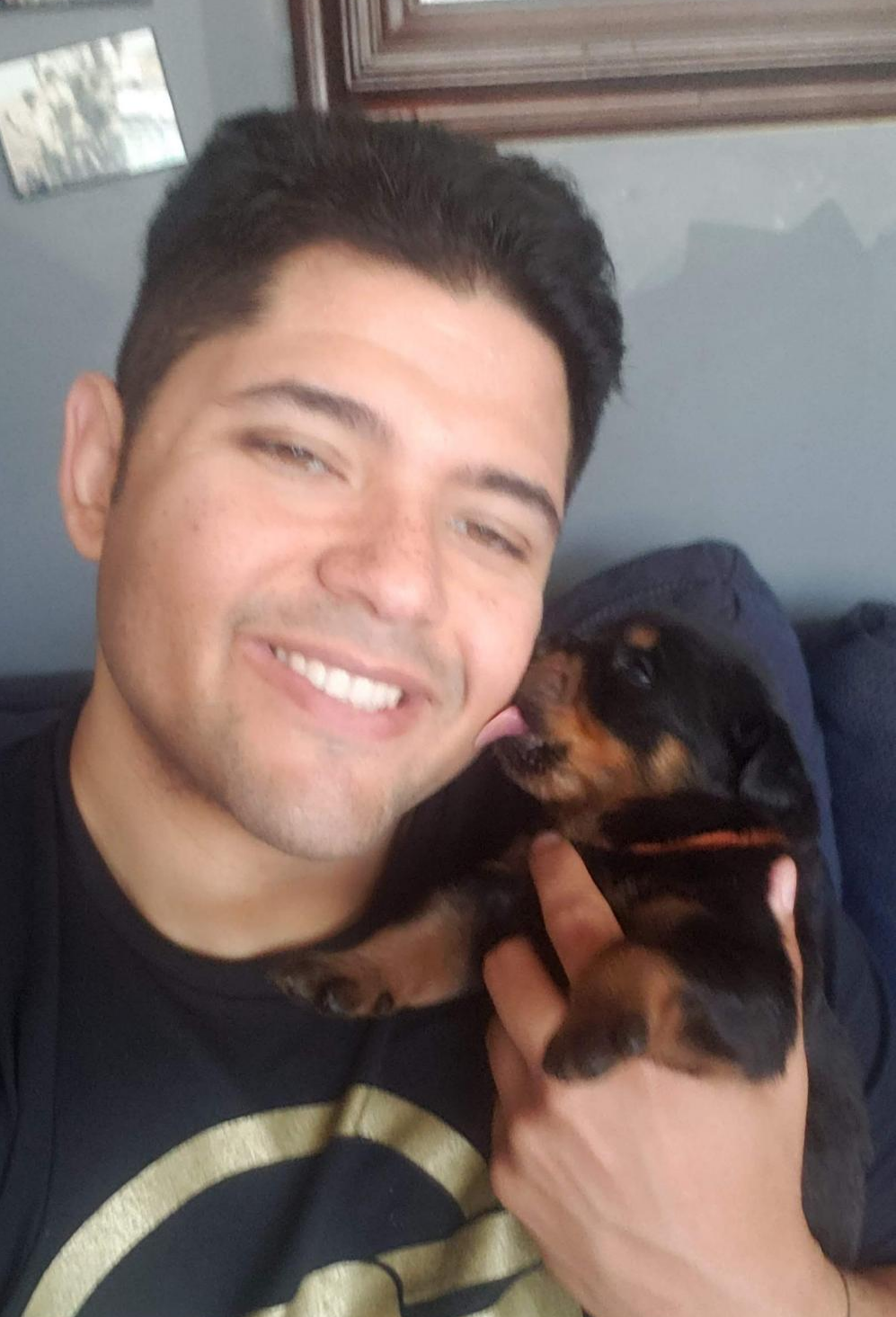 Kennel owner holding Rottweiler pup while smiling