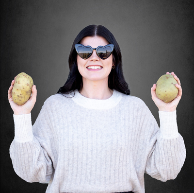 Dental Assistant, Caitlee holding two potatoes and wearing sunglasses.