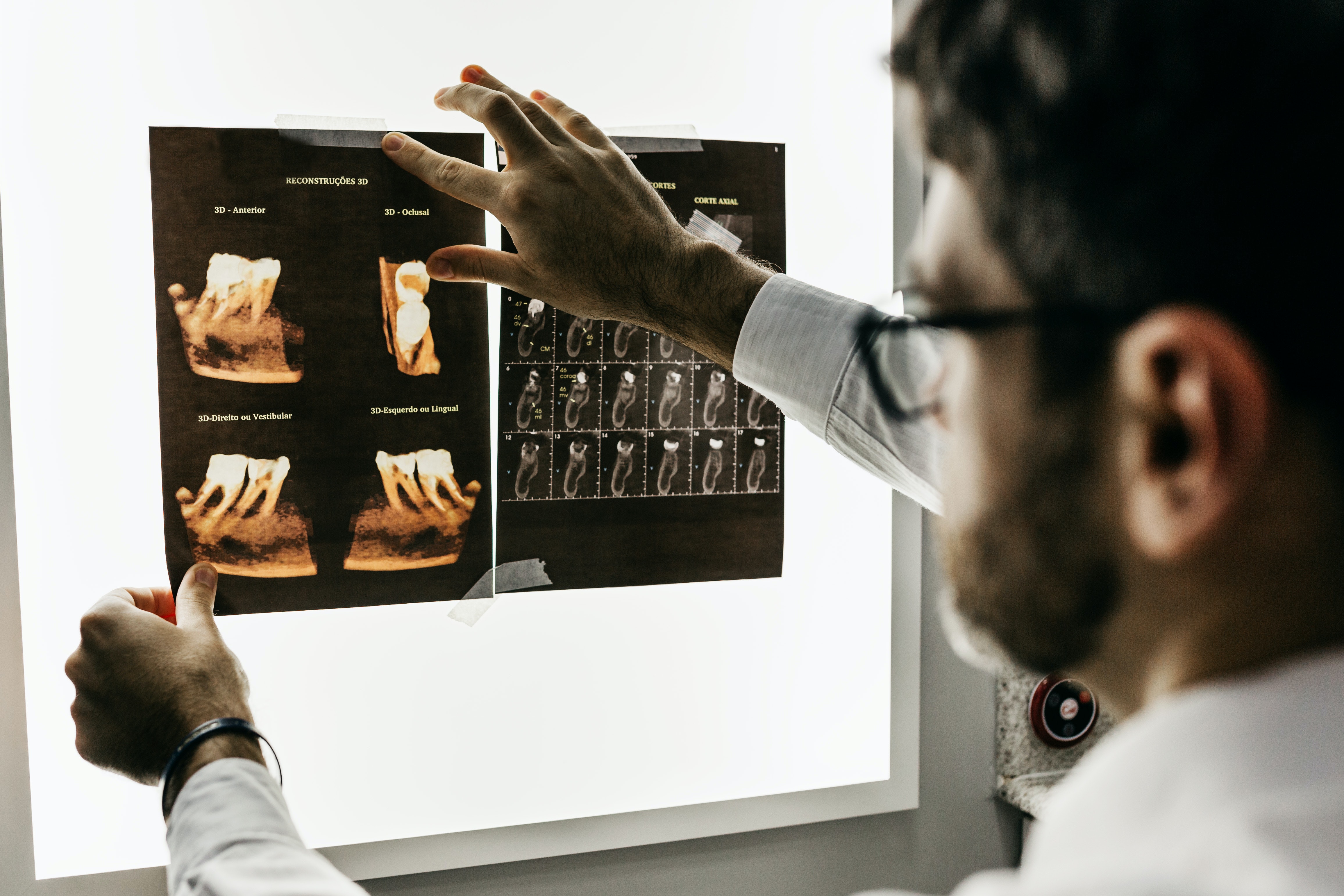A dentist examining oral x-rays.