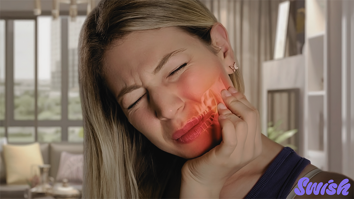 A woman holding her jaw in pain.