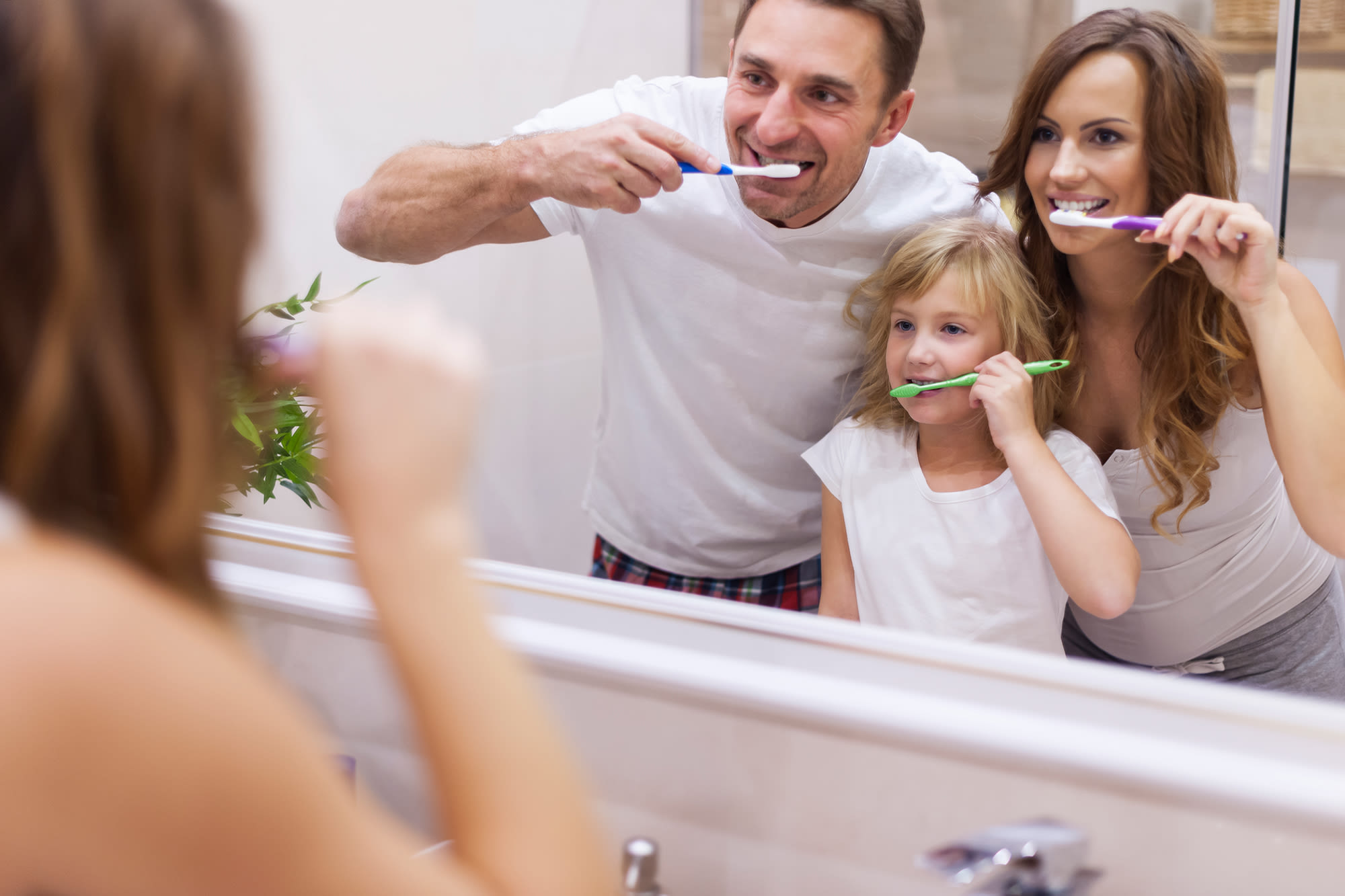 A family brushing their teeth together.