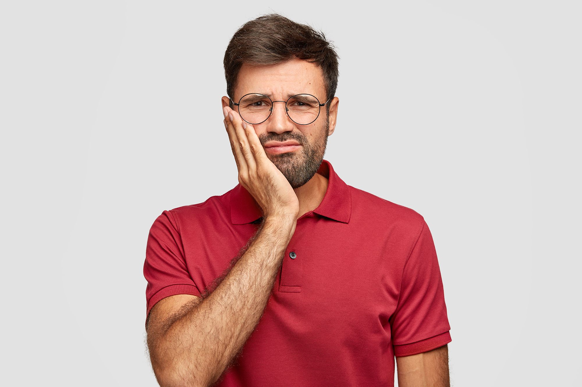 A man holding his jaw in pain.