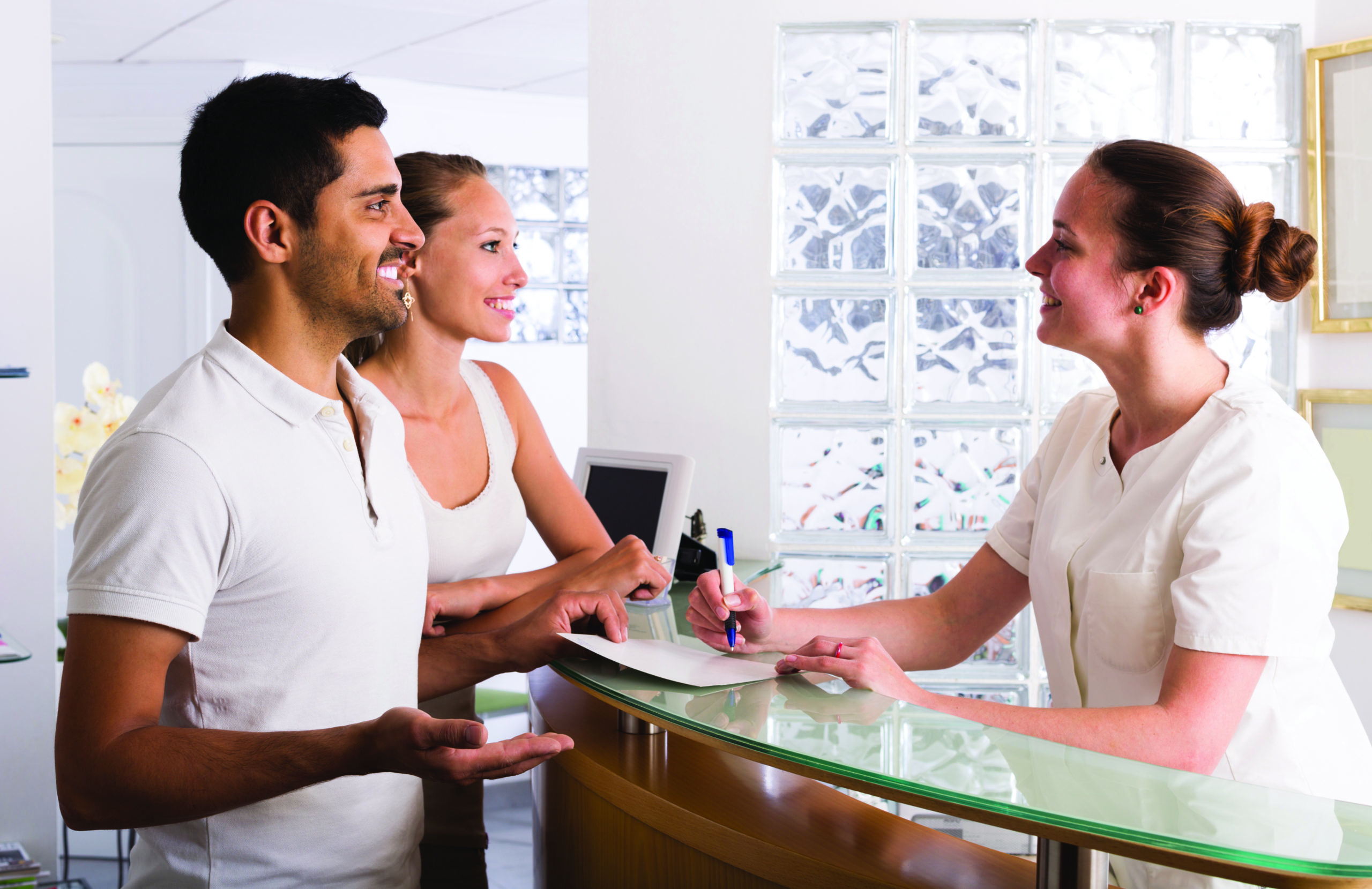 A receptionist greeting people as they walk in.