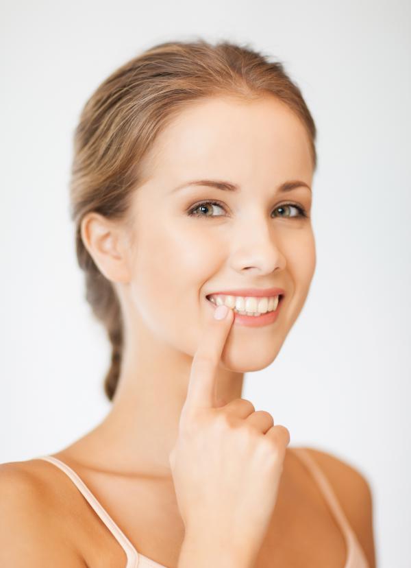 A woman pointing to her teeth.