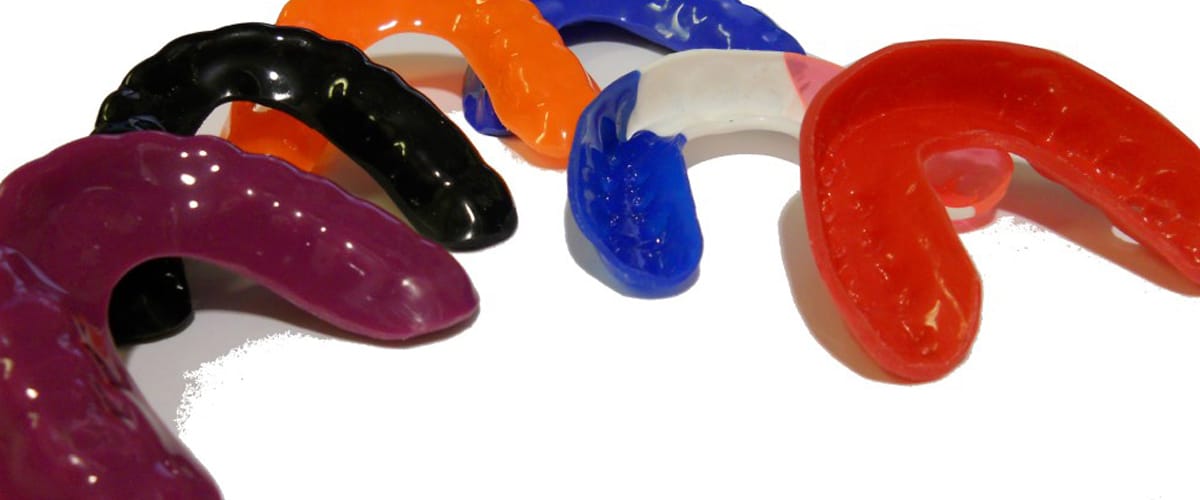 A variety of mouthguards in different colors.