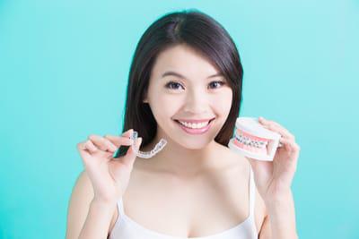 woman holding various aligners