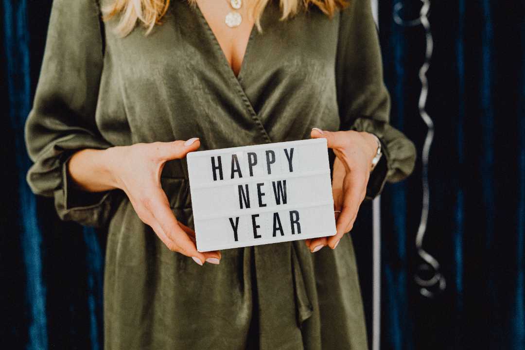woman holding a happy new years sign