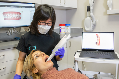 A dental hygienist examining the mouth of a full mouth reconstruction patient