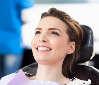 women in dentist chair smiling with nice teeth