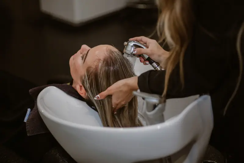 a blonde woman having her hair washed
