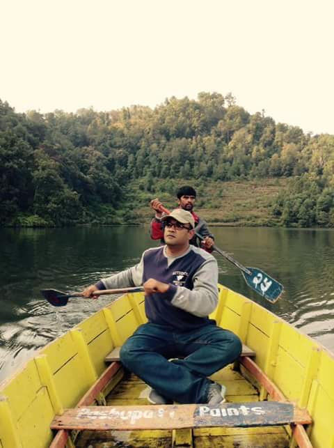 Alok Das paddling a boat to deliver plants to Begnas Lake